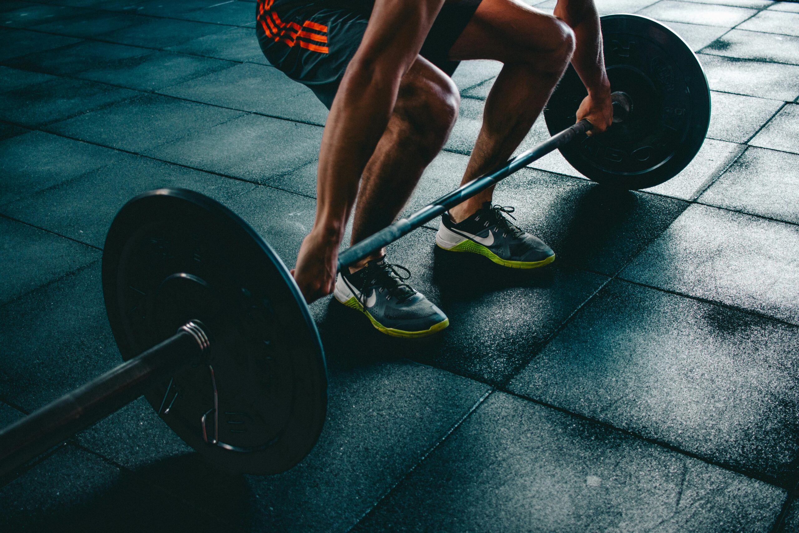 Home Man performing a deadlift exercise in a gym, demonstrating strength and fitness.